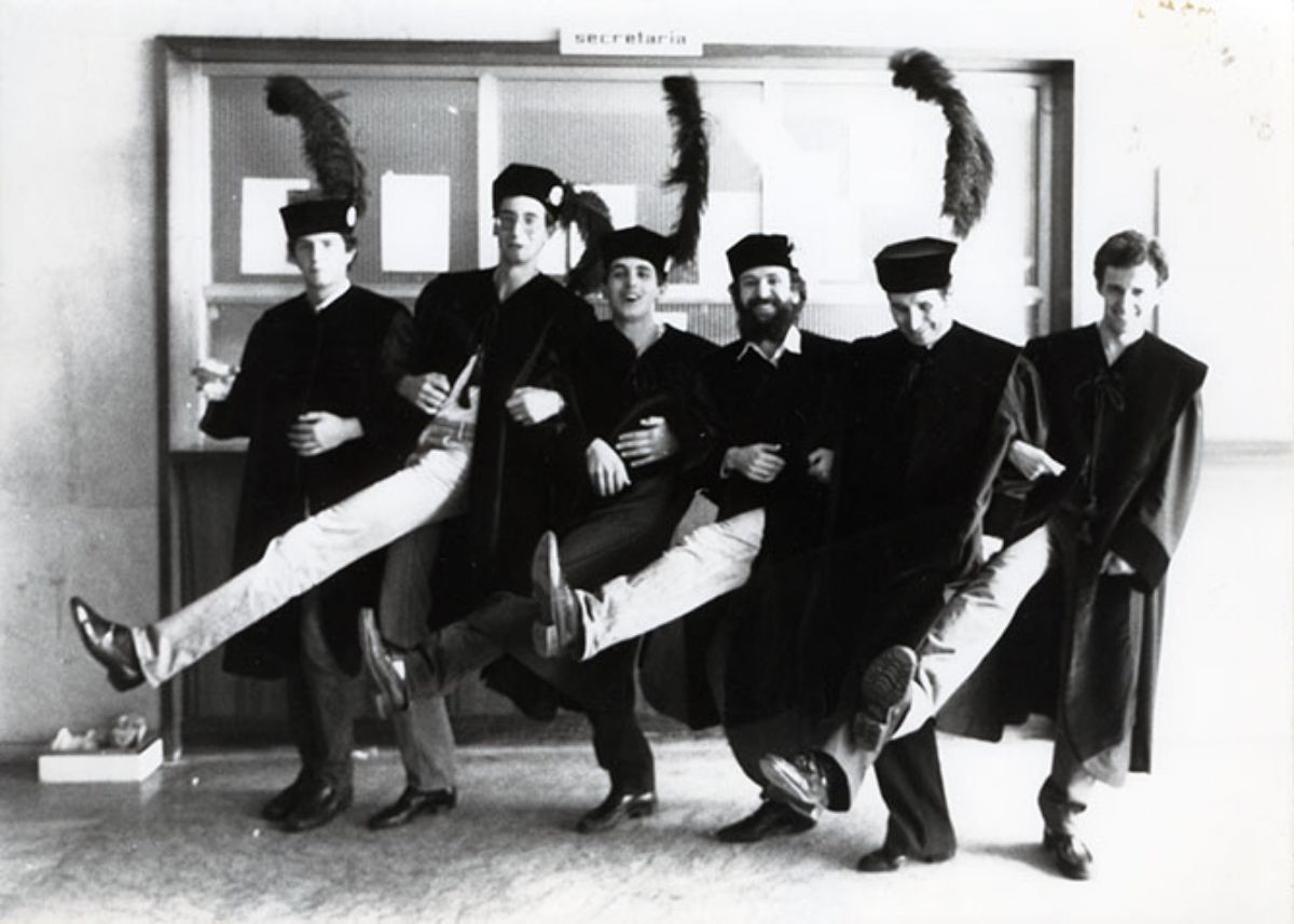 Grupo   de bedeles de la Universidad bailando, revestidos con el traje de Macero,   caracterizado por el birrete y pluma de color negro y utilizado en los actos   académicos de la Universidad