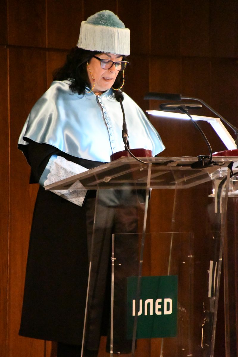 La   escritora Almudena Grandes, en su ceremonia de investidura Doctora Honoris   Causa por la UNED, realizando su discurso de agradecimiento desde el atril   (2020) 