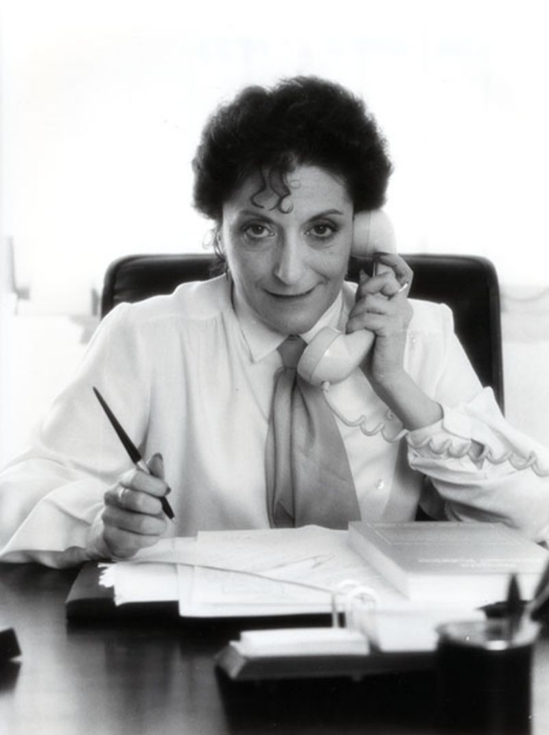 Retrato en blanco y negro de Elisa Pérez Vera, Rectora de la UNED entre 1982 y 1987, hablando por teléfono en la mesa de su despacho (Imagen de A.V. Gilbert-A. Rigaud, 1983).