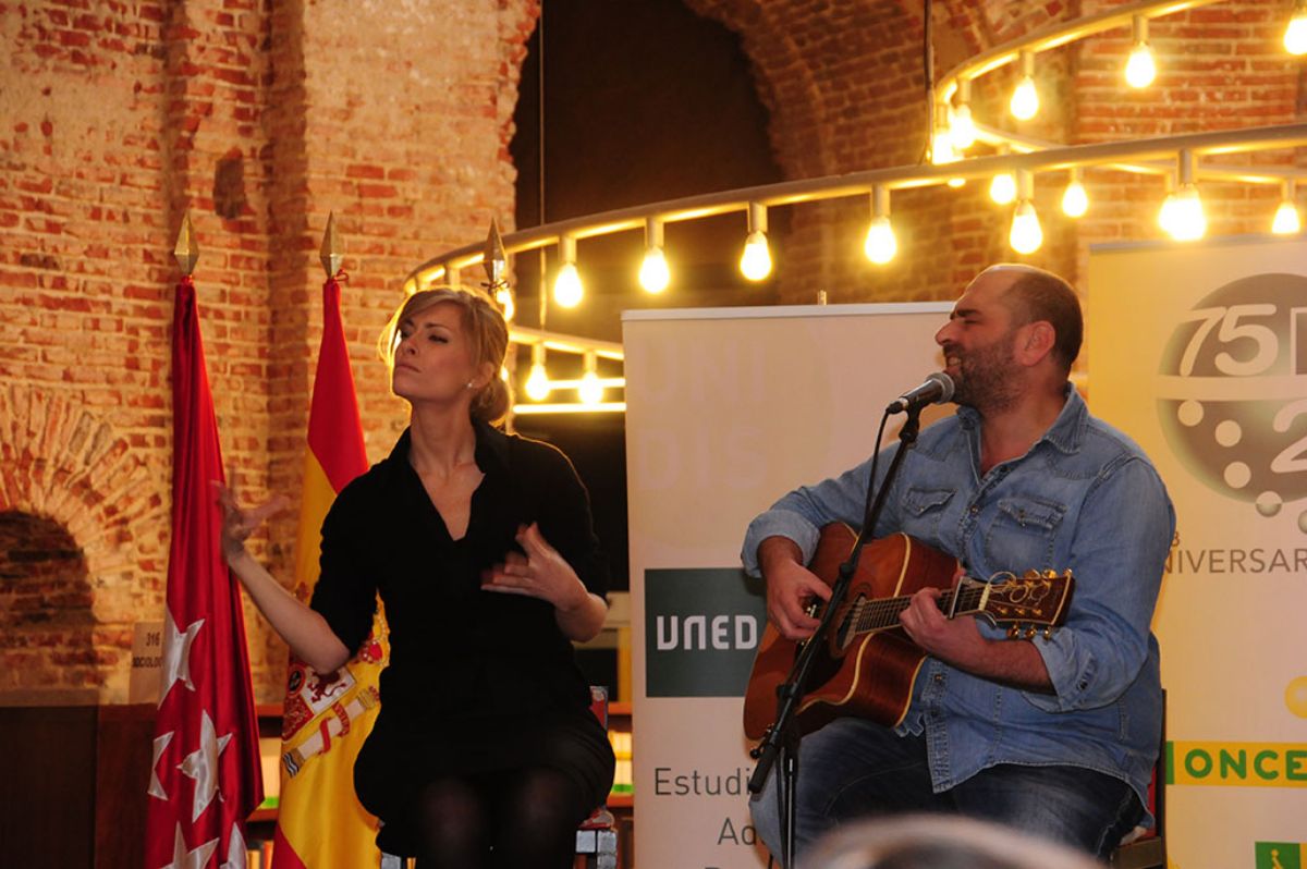 El   cantante Tontxu junto a Evelyn Vega, intérprete que traduce su canción al   lenguaje de signos, durante el concierto de guitarra titulado "Música   para los ojos", formando parte del espectáculo "Talento en la UNED:   rompiendo barreras" Imagen de José Rodríguez, 2013)