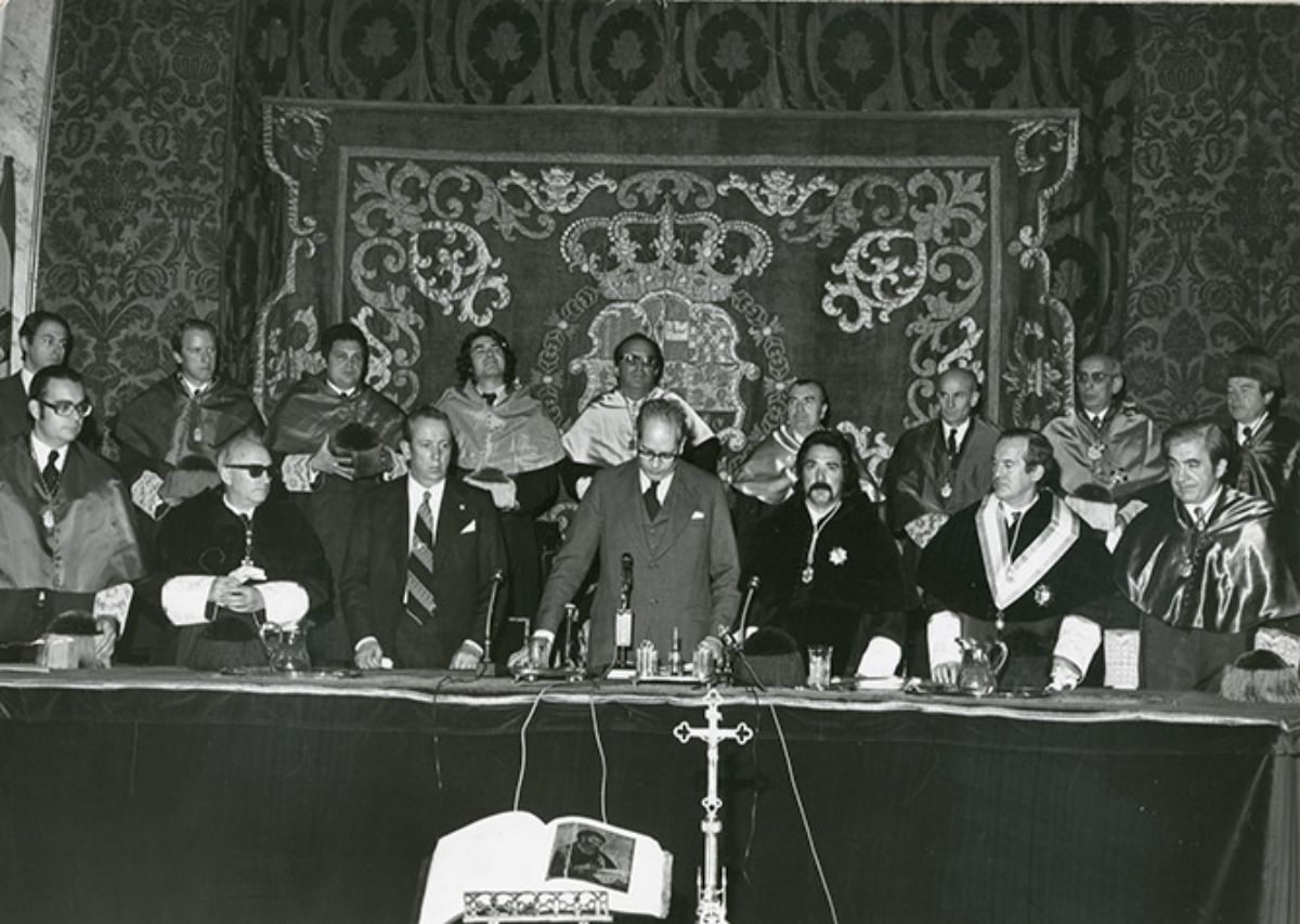 La   mesa presidencial durante el Acto de apertura del curso académico 1976.   Preside el acto el Ministro de Educación y Ciencia, Carlos Robles Piquer que   dirige unas palabras a los asistentes (Imagen de Poli-Rub, 1976)
